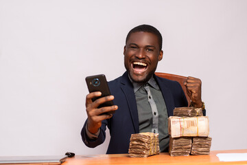 happy african businessman with lots of money using a phone