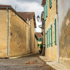 Fototapeta premium Summer city landscape - view of a medieval street in a provincial French town, in the historical province Gascony, the region of Occitanie of southwestern France
