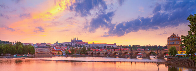 Fototapeta na wymiar City summer landscape at sunset, panorama, banner - view of the Charles Bridge and castle complex Prague Castle in the historical center of Prague, Czech Republic