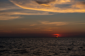 Fototapeta na wymiar smutna żaglówka na tle zachodzącego nad Bałtykiem słońca