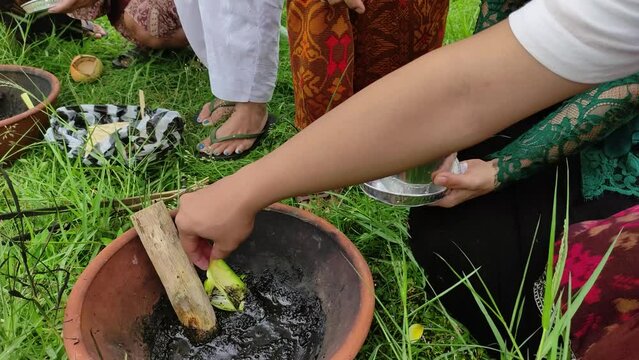 Ngaben or cremation ceremony in Bali, Indonesia. It is performed to release the soul of a dead person. The stage of pounding the remaining bones in the Ngaben tradition.