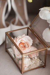 Wedding rings in the box and the bride's bouquet of roses and orchids