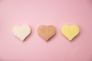 Heart shaped pink bar of soap on a light pink background. Top view, copy space. Heart shaped soaps. Importance of personal hygiene care. Copy space.