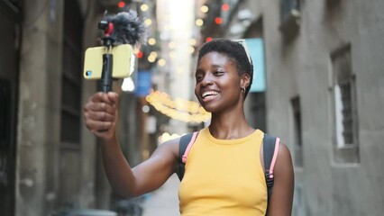 Young woman using a smartphone while creating content for her social networks outdoors on the street.