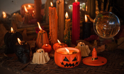 Halloween composition pumpkin orange candles, mystical design for home, interesting ideas for party, details of décor
