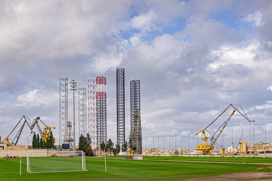 A Socker Stadium With The Port Constructions In The Background