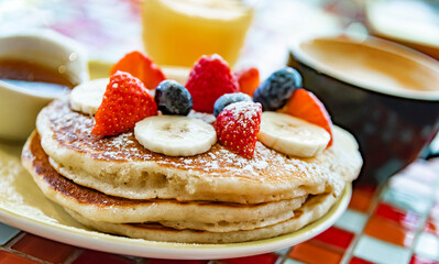 Belgian pancakes served with fruits and maple syrup