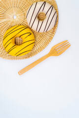 Top view, isolated donuts and chocolates on a wooden tray, placed on a wicker coaster. Make a beautiful view