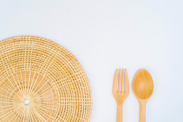 View from top of placemats, wicker coasters, wooden spoons, wooden drills on a white background.