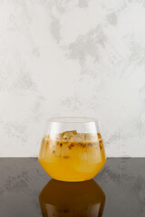 Glass of Yuzu iced fizzy lemonade with Passion fruit and Orange juice. Refreshing Iced drink. Fruit citrus cocktail