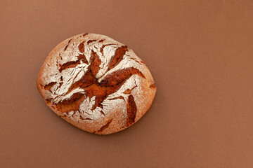 Fresh crisp rye bread on brown background. Freshly baked handmade Bread at leaven