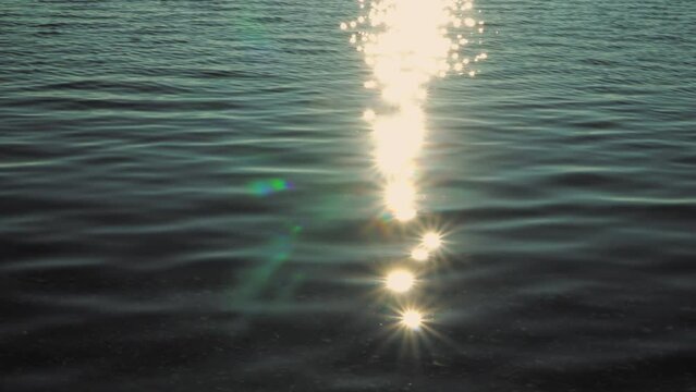 Reflected sun rays on the blue calm sea water