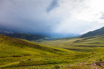 Fototapeta na wymiar Endless pastures in the valley of the Assy plateau under thunderclouds