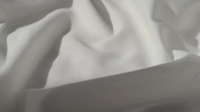 White fabric. Drapery wavy texture white linen cloth background on morning sunshine. Clean clothes concept.