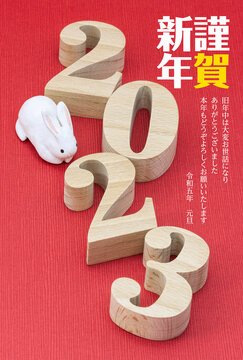 2023年賀状・明朝体の木製数字と干支の人形