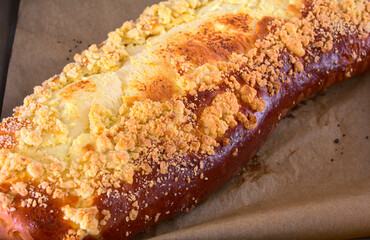 Close up of a large browned curd strudel (yeast-cake) with crumble. Cake freshly removed from the...