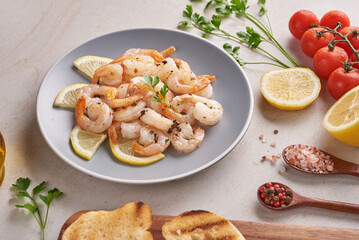 Olives, oil, Grilled shrimps and fresh vegetable salad on a wooden board on black slate stone board over dark background, juicy tomatoes on fresh bread, pesto as topping. top view. Flat lay
