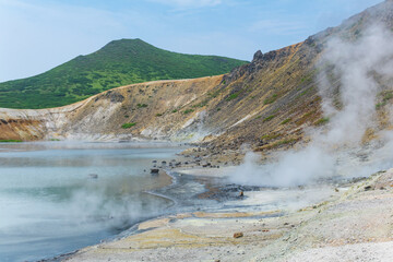 hot mineralized lake with thermal spring and smoking fumaroles in the caldera of the Golovnin volcano on the island of Kunashir