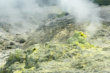 volcanic landscape with smoking vents of sulfur fumaroles