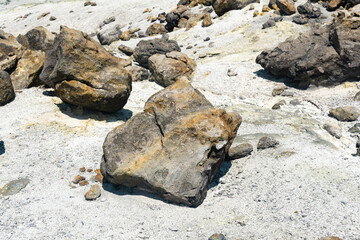volcanic bombs among the tephra in a fumarole field on the slope of a volcano