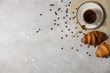Fototapeta premium Tasty fresh croissants and coffee on light grey marble table, flat lay. Space for text