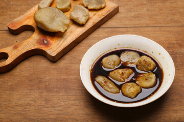 empek empek with cuka or vinegar sauce in a white bowl. emepek enpek is a typical food from Palembang Indonesia. pempek palembang. Indonesian dish