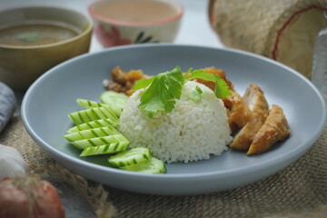 Hainanese chicken rice with fried chicken, fried chicken served with sweet dipping sauce and chicken broth, Asian style, street food commonly sold in Asia.