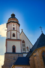 Fototapeta premium Historische Thomaskirche in Leipzig bei strahlendem Sonnenschein, Wirkungsstätte von Johann Sebastian Bach unter blauem Himmel, Sachsen, Deutschland