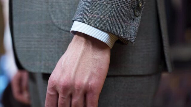 Hand showing correct shirt sleeve length with suit jacket, close up.
