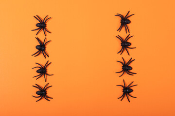 Fototapeta na wymiar Close up of multiple spider toys with copy space against orange background