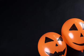 Two halloween pumpkin printed balloons with copy space on black background - Powered by Adobe
