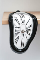 Decorative clocks drain off the shelf. The clock is a symbol of the impermanence of time.