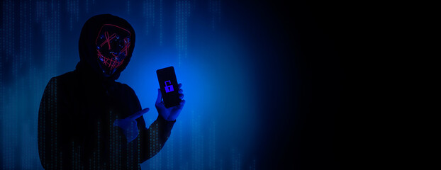 Digital security Concept. Anonymous hacker with mask holding smartphone hacked. Personal and Cyber...