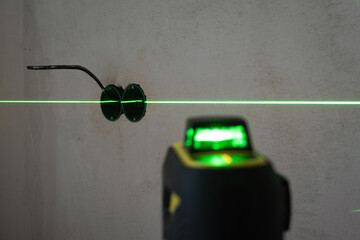 Electrical wiring work on the wall using laser level device. Plastic back boxes for sockets and...