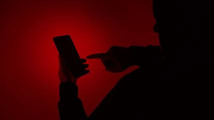 Digital security Concept. Anonymous hacker with mask holding smartphone hacked. Personal and Cyber...