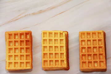 sweet baked fluted Belgian waffles on a gray marble background