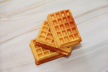 sweet baked fluted Belgian waffles on a gray marble background