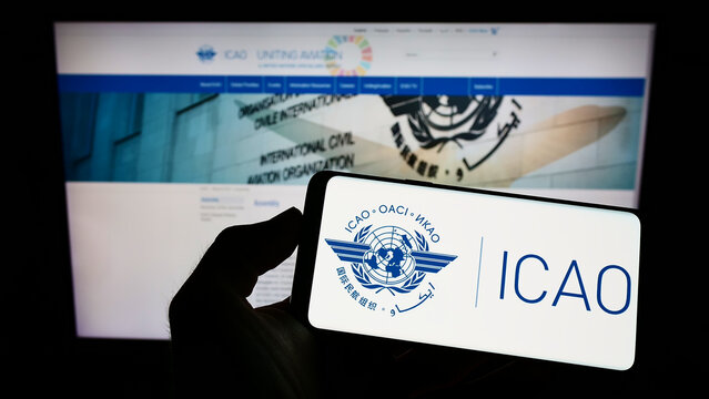 Stuttgart, Germany - 09-04-2022: Person holding cellphone with logo of International Civil Aviation Organization (ICAO) on screen in front of webpage. Focus on phone display.