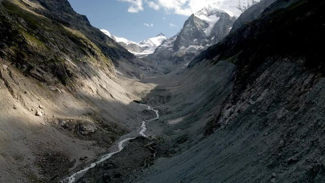 Aerial view following the mountain river between the mountains in the valley of Zinal, Switzerland