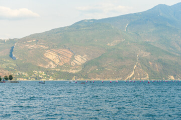 Big group of optimist dinghies sailing and training on the beautiful Garda lake, Trentino, Italy....