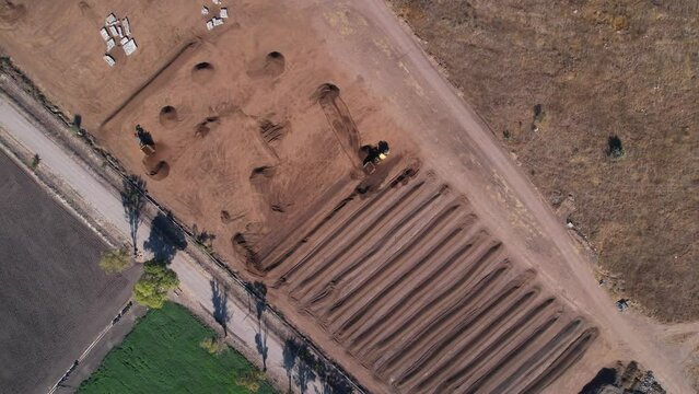 slow aerial rotation of yellow tractor working on a compost farm in Mexico