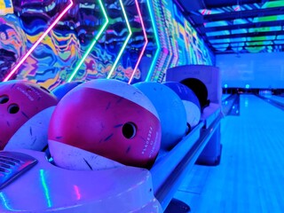 Image of bowling ball at a bowling alley with colorful side walls shot at night