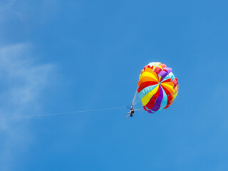 Two tourists are flying on a colored parachute