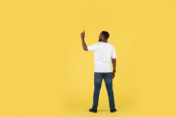 Fototapeta na wymiar African American Man Pointing Finger Pushing Invisible Button, Yellow Background