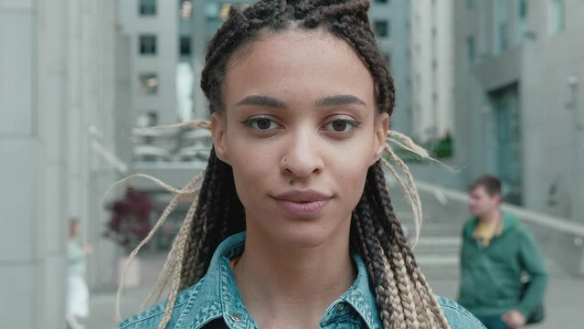 Portrait of Beautiful Stylish African American Woman With dreadlocks Smiling At Camera With Confidence In The City, Wearing in a denim jacket, Close Up Shot