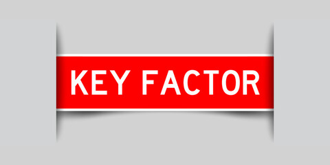 Inserted red color label sticker with word key factor on gray background