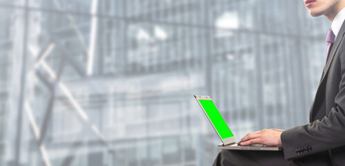 businessman works on laptop with green screen on for chroma key - People isolated on modern office background