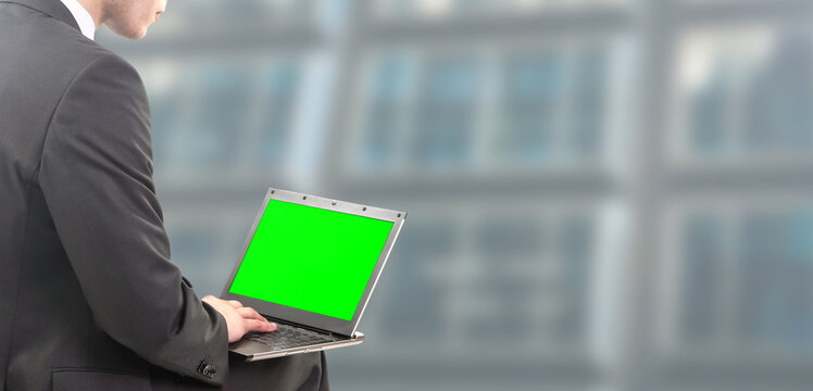 Businessman Works On Laptop With Green Screen On For Chroma Key - People Isolated On Modern Office Background