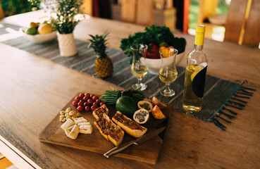 Selective focus on snack platter food and alcohol white wine at table, sandwich and vegetables as starter for have bite during dinner or lunch - appetizer brunch with delicious healthy ingredients