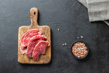 Raw beef meat on a wooden cutting board